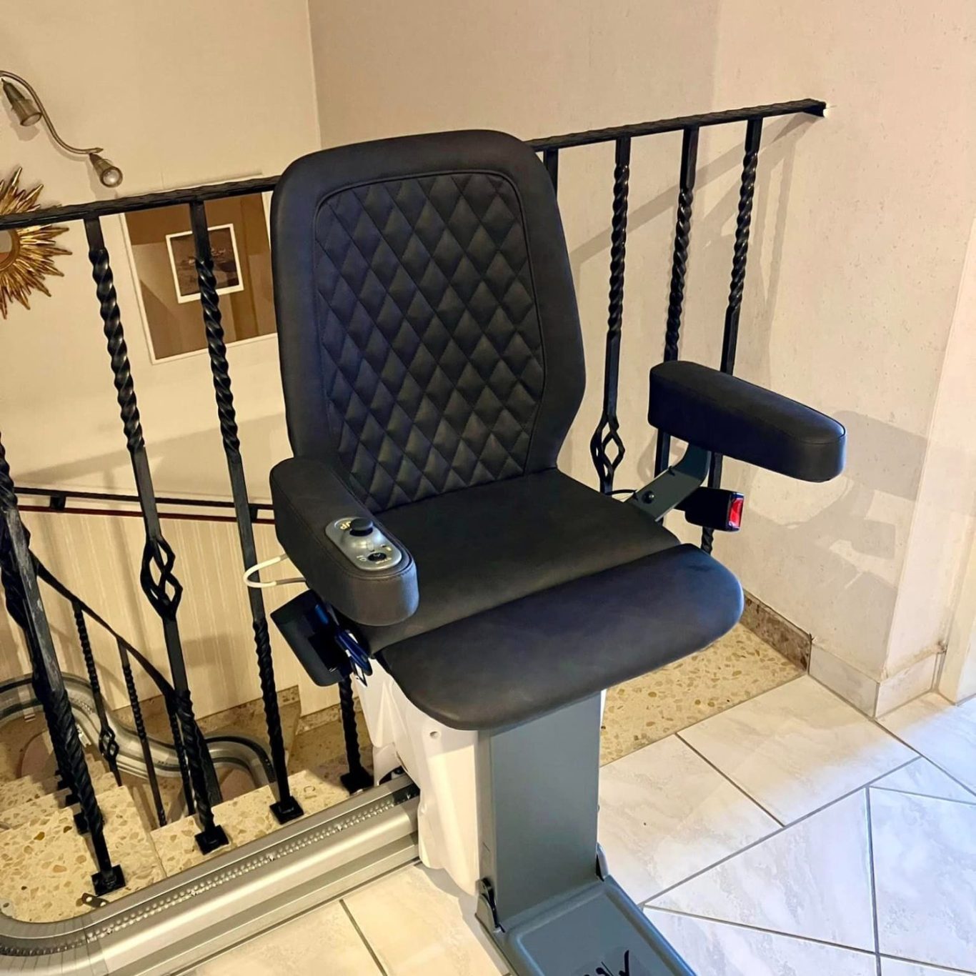 Treppenlift mit schwarzem Sitz und Armlehnen, montiert an einem Treppenabsatz in Vlotho Treppenlift mit schwarzem Sitz und Armlehnen, montiert an einem Treppenabsatz.